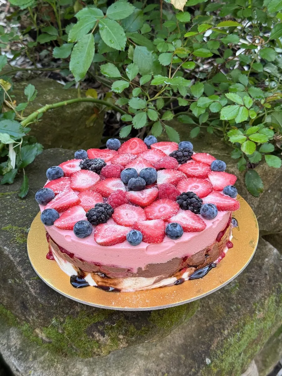 Eistorte, dicht belegt mit frischen Erdbeeren und Heidelbeeren